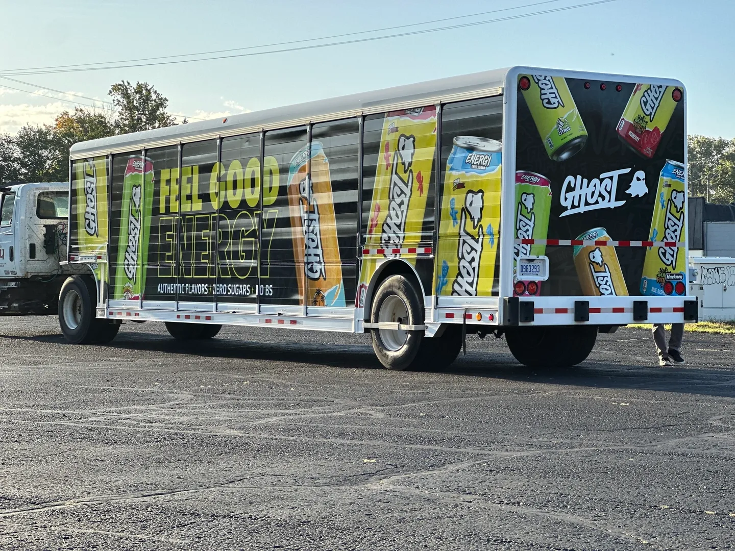 A large bus with advertisements on the side of it.