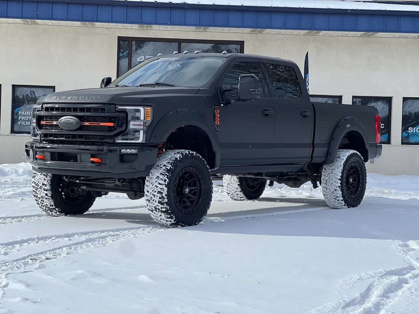 A black truck is parked in the snow.