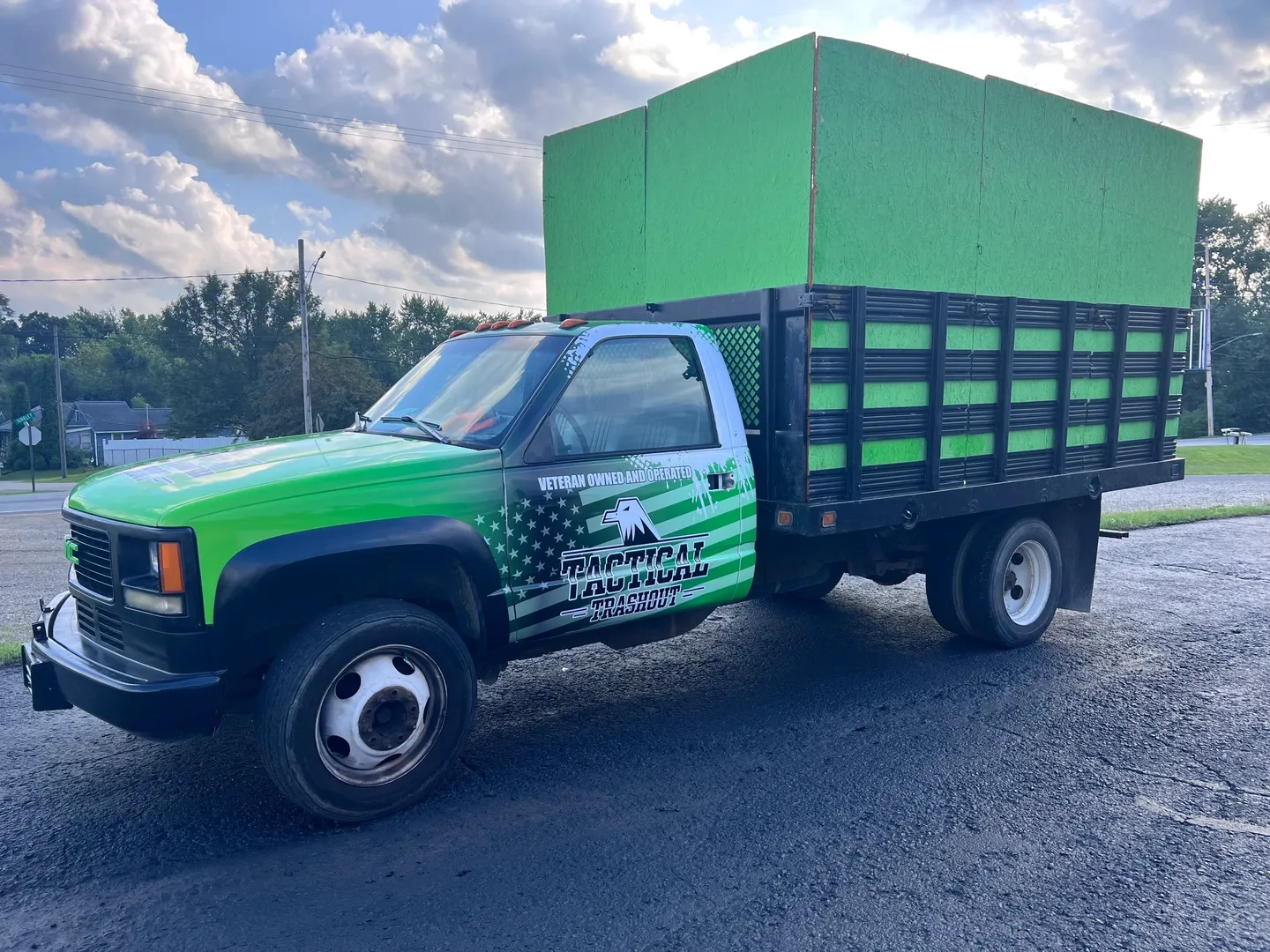 A truck with a green box on the back of it.